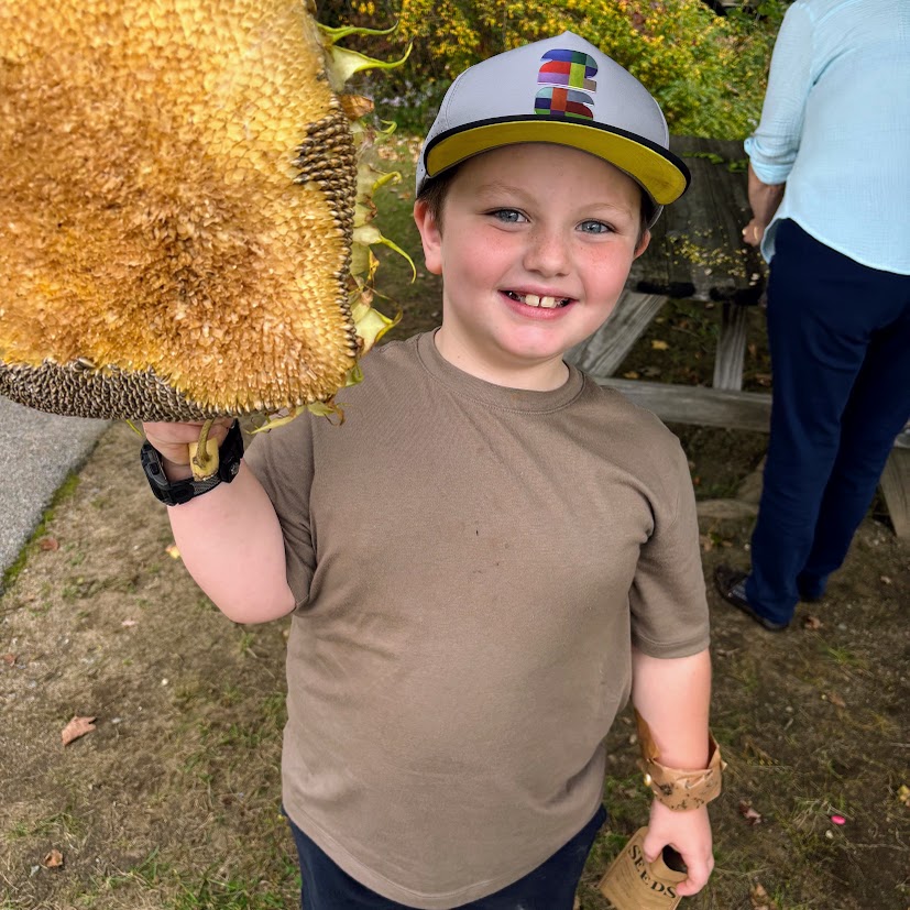 Student holds up giant sunflower.